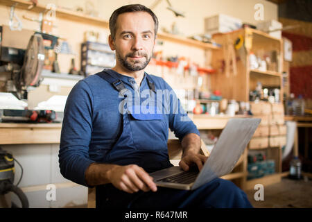 Mature Carpenter Posing with Laptop Stock Photo