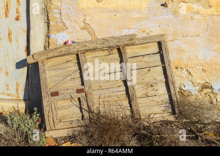 Old Spanish Wooden Door, Propped up against a Farm House Stock Photo