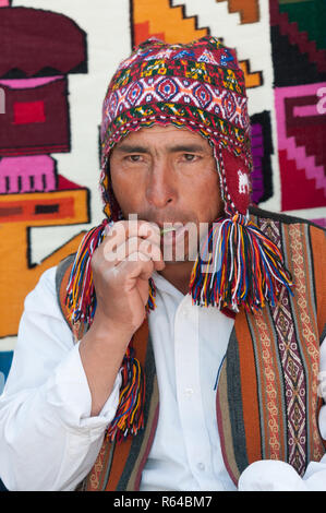 Chincheros, Peru - July 31 2011: A man wearing typical clothes, eating leaves of coca. Stock Photo
