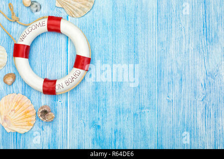 Maritime themed background with sea shells and lifebuoy on weathered blue painted wooden boards with copy space on right side. Stock Photo