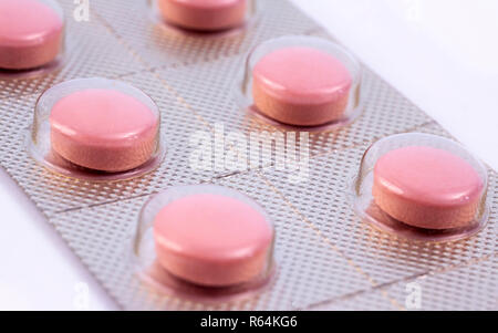 Pink pills in silver plastic pack - blister. Global pharmaceutical industry for billions dollars per year. Pharmaceutical drugs for use as medications Stock Photo