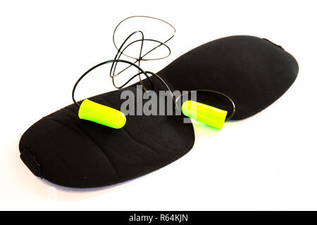 Black sleeping mask with green ear plugs isolated on a white background. Studio shot. Stock Photo