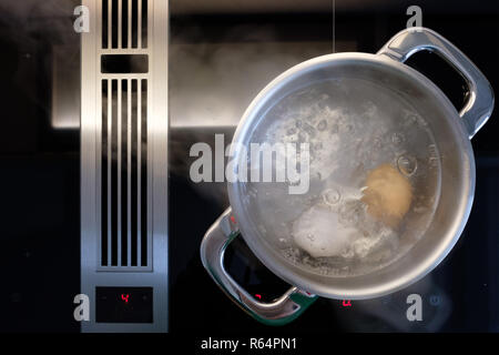 boil eggs in water in saucepan on stove Stock Photo