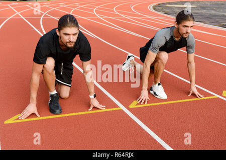 Photo of young two twins sportsmen brothers ready to run outdoors. Stock Photo