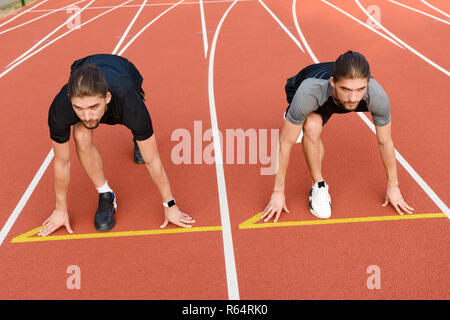 Photo of young two twins sportsmen brothers ready to run outdoors. Stock Photo