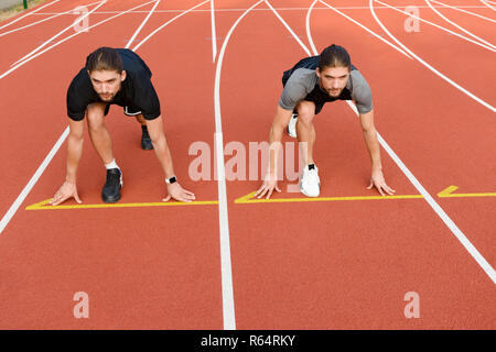 Photo of young two twins sportsmen brothers ready to run outdoors. Stock Photo