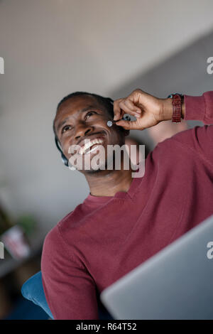 Emotional dark skinned male freelancer celebrating completed project successfully. Stock Photo