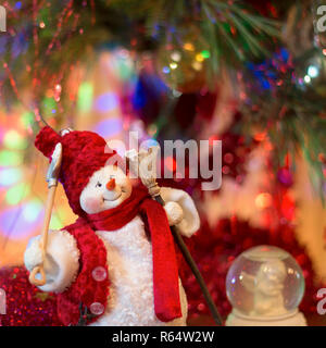 Cheerful snowman with broom and shovel against bokeh background. Good New Year spirit. New Year, Christmas concept Stock Photo