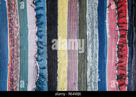 Traditional rustic rug with a striped pattern. Background of multi-colored carpet floor Stock Photo