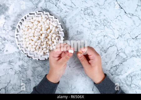 Diy marshmallow garland. Guide on photo how to make a decorative marshmallow garland, threads, needles and branches with your own hands. Handmade Chri Stock Photo