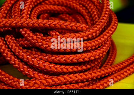 shimmering orange nylon rope background, coiled orange industrial rope made of nylon or synthetic Stock Photo