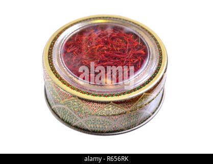 Delicate saffron threads, plucked from crocus flowers and dried. In the ethnic box. Isolated on white background. Stock Photo