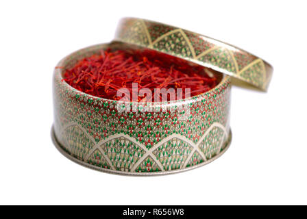 Delicate saffron threads, plucked from crocus flowers and dried. In the ethnic box. Isolated on white background. Stock Photo