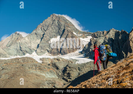 Two alpinists watching Grossglockner peak in autumn, East Tyrol, Austria Stock Photo