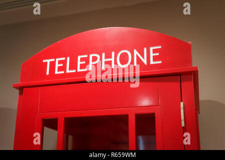 Traditional red phone box stands indoors as a symbol of London and the UK Stock Photo