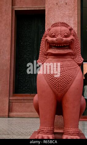 Red lion standing guard to ward off evil and prevent ill will in Asia Stock Photo