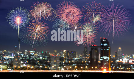 Colorful fireworks on blur city skyline background at night Stock Photo