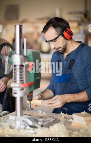 Mature Worker Drilling Wood Stock Photo