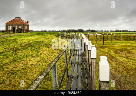 Schokland, The Netherlands, October 24, 2018: View along the length of a wooden jetty in the reconstructed harbour on the former island. Stock Photo