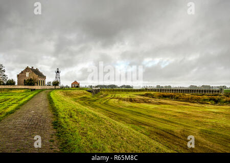 Schokland, The Netherlands, October 24, 2018: Dramatic skies over the former island with its lighthouse and reconstructed harbouras well as the surrou Stock Photo