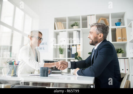 Happy business partners making handshake as symbol of cooperatio Stock Photo