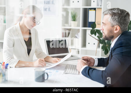Financial adviser analyzing papers with businessman Stock Photo