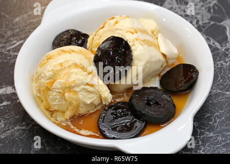 vanilla ice cream with black nuts in syrup Stock Photo