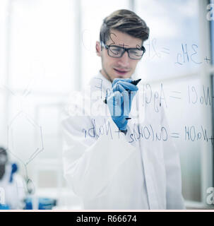 scientist making notes on the glass Board at the time of the experiment Stock Photo