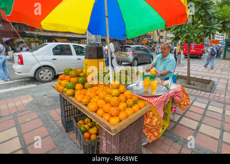 Medellin January 2018  In the morning, an old man sells fresh mandarins on his stall in a street in the center of Medellin because people love to buy  Stock Photo