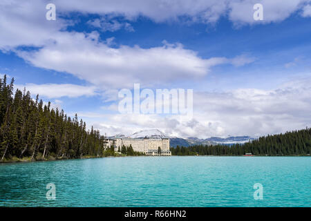 LAKE LOUISE, AB, CANADA - JUNE 2018: Wide angle view of the Fairmont Chateau Lake Louise hotel with snow capped mountains in the background and the em Stock Photo