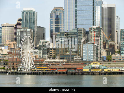 SEATTLE, WASHINGTON STATE, USA - JUNE 2018: Cityscape of waterfront, big wheel, and office buildings in downtown Seattle as viewed from Puget Sound. Stock Photo