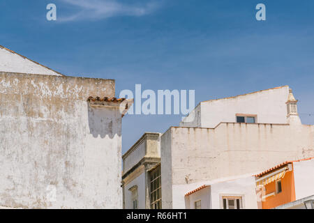 White buildings and angled rooflines of old buildings in the historical city center of Tavira, Portugal Stock Photo