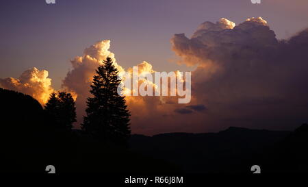 thunderclouds pile up behind a weathercane Stock Photo