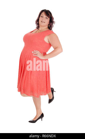 A plus size woman standing in a red dress Stock Photo
