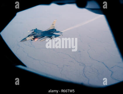 A U.S. Air Force F-16 Fighting Falcon pulls away after being refueled by a 28th Expeditionary Aerial Refueling Squadron KC-135 Stratotanker in support of Operation Inherent Resolve, Nov. 29, 2018. The F-16 Fighting Falcon is a compact, multi-role fighter aircraft that has proven itself in air-to-air combat and air-to-surface attack.  (U.S. Air Force photo by Staff Sgt. James Cason) Stock Photo