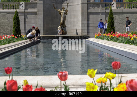 Young people have fun around a reflecting pool in Congress Park, Saratoga Springs, NY, USA. Stock Photo