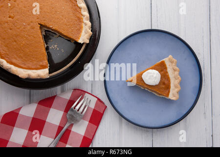 An overview of a plate of pumpkin pie with a napkin and fork. Stock Photo