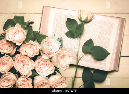 Roses bouquet and an open book in retro style Stock Photo
