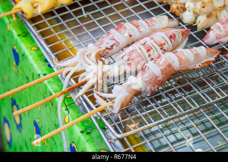 Grilled squid placed on a stainless steel sieve. Stock Photo