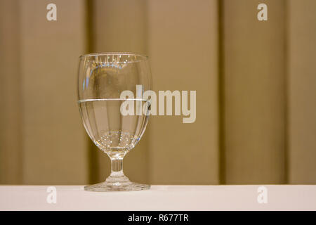 Water glass with brown background. Stock Photo