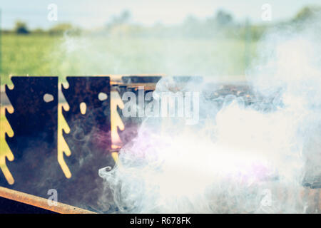 an old rusty steaming barbecue when lighting in garden Stock Photo