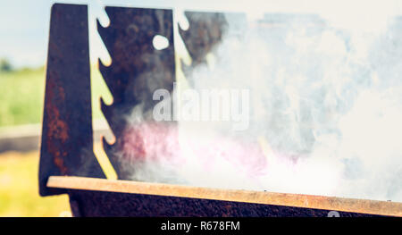 an old rusty steaming barbecue when lighting in garden Stock Photo