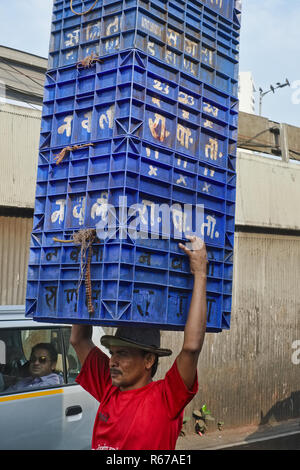 A porter at a fish market behind Crawford Market in Mumbai, India, carries an impressive tower of plastic crates on his head Stock Photo