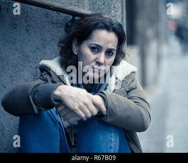 Attractive woman suffering from depression felling sad unhappy heartbroken and lonely sitting in city urban street in Mental health Emotional pain Abu Stock Photo