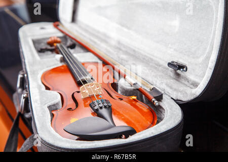 brown vintage violin with bow lying in a case closeup indoor Stock Photo