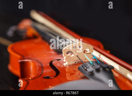 brown vintage violin with bow lying on a piano closeup indoor Stock Photo