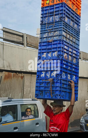 A porter at a fish market behind Crawford Market in Mumbai, India, carries an impressive tower of plastic crates on his head Stock Photo