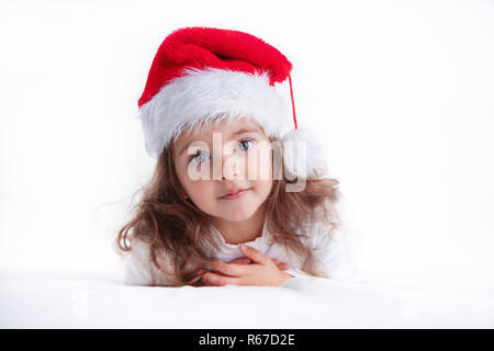 Christmas time, little girl in Santa Claus hat smilling. Stock Photo