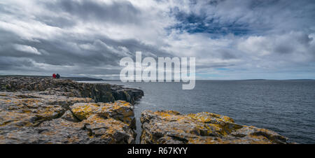 People on the cliffs in Doolins Bay Stock Photo