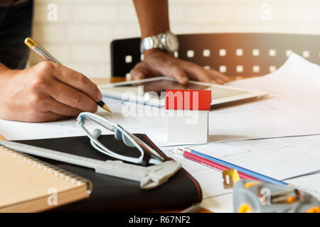 Architect or engineer using pen working on blueprint, architectural concept Stock Photo